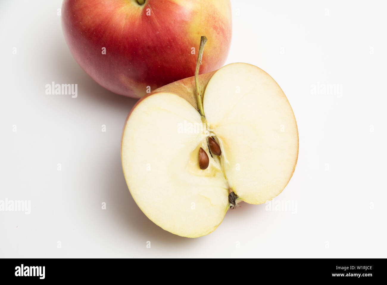 Description: Ripe fruit of red-green Apple with half of Apple Stock Photo