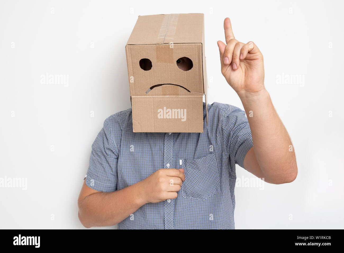 Description: a man with a cardboard box on his head, a sad smiley Stock Photo