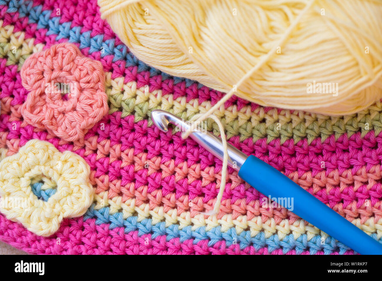 Crocheted colorful background with crochet hook and a wool ball Stock Photo