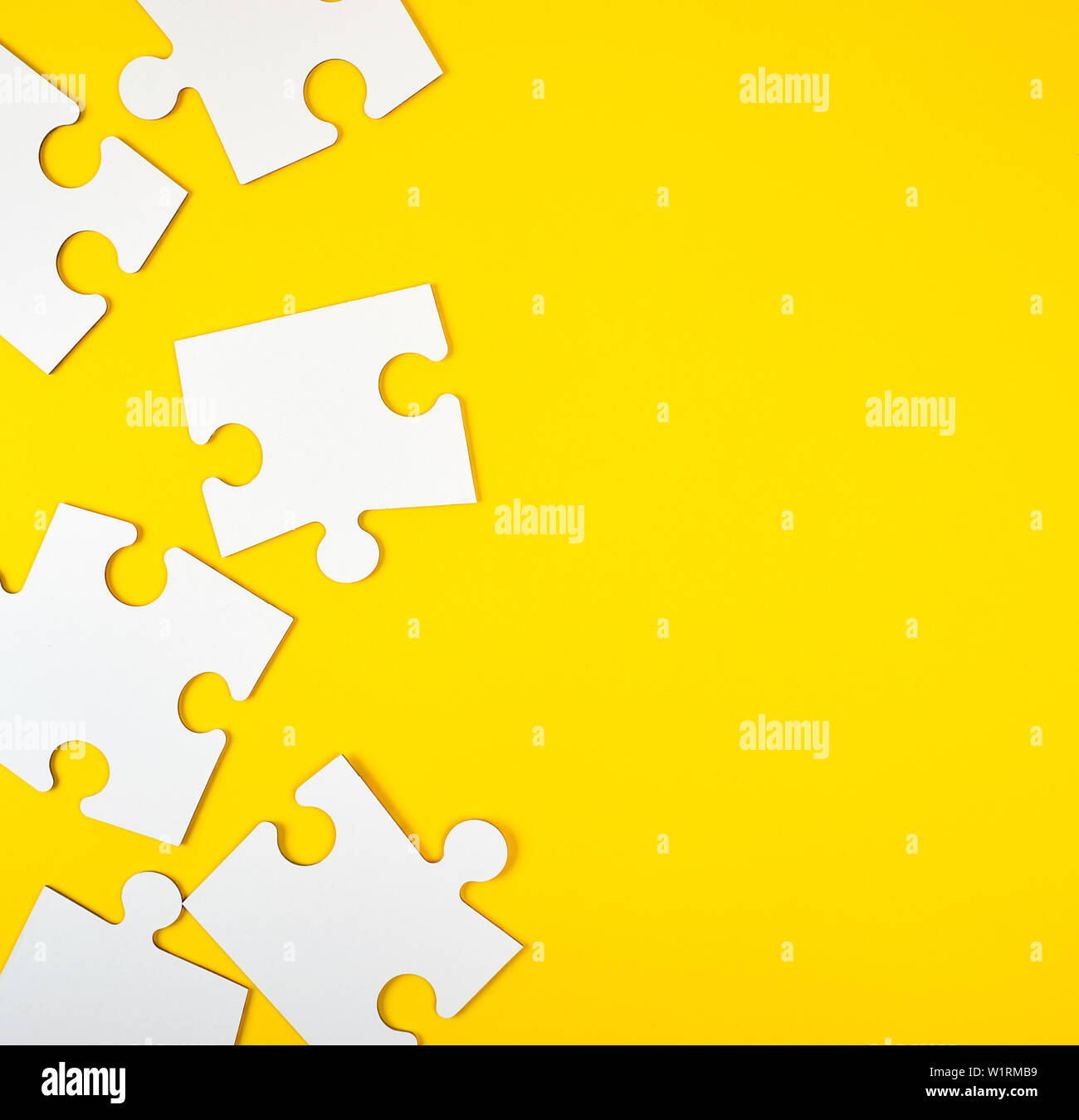 blank white big puzzles on yellow background, flat lay Stock Photo