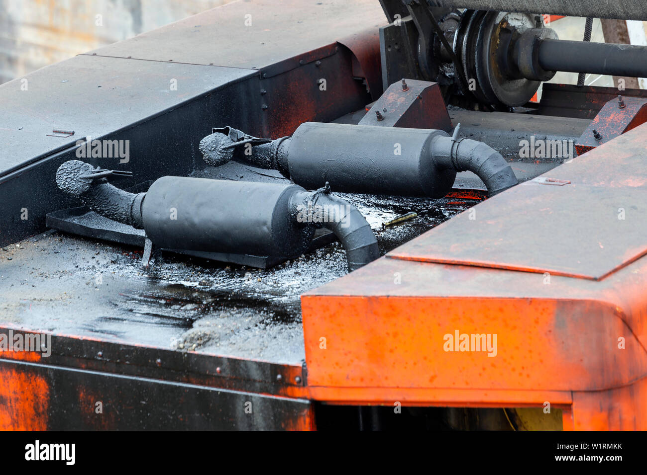 Old exhaust pipe with oil of industrial machine at construction site