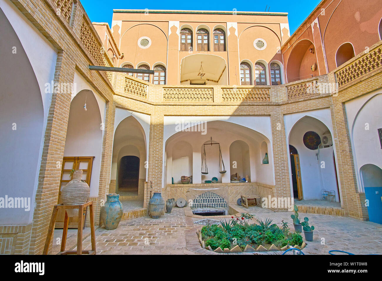 KASHAN, IRAN - OCTOBER 23, 2017: The shady courtyard of traditional Iranian house with many narrow corridors, to provide cool air and wind, on October Stock Photo