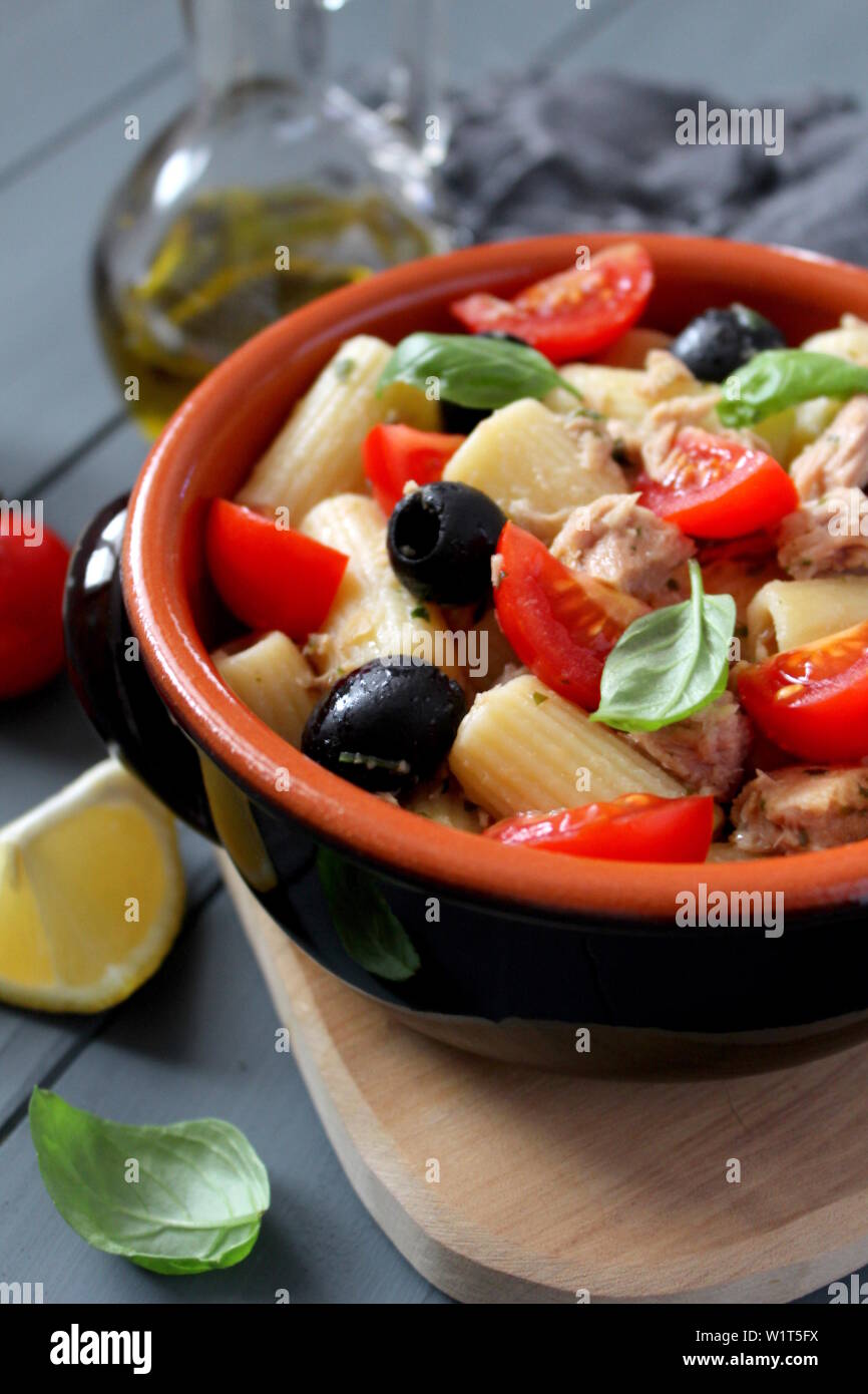 Pasta with tuna, tomato, black olive and parmesan cheese on dark background. Top view with copy space. Stock Photo