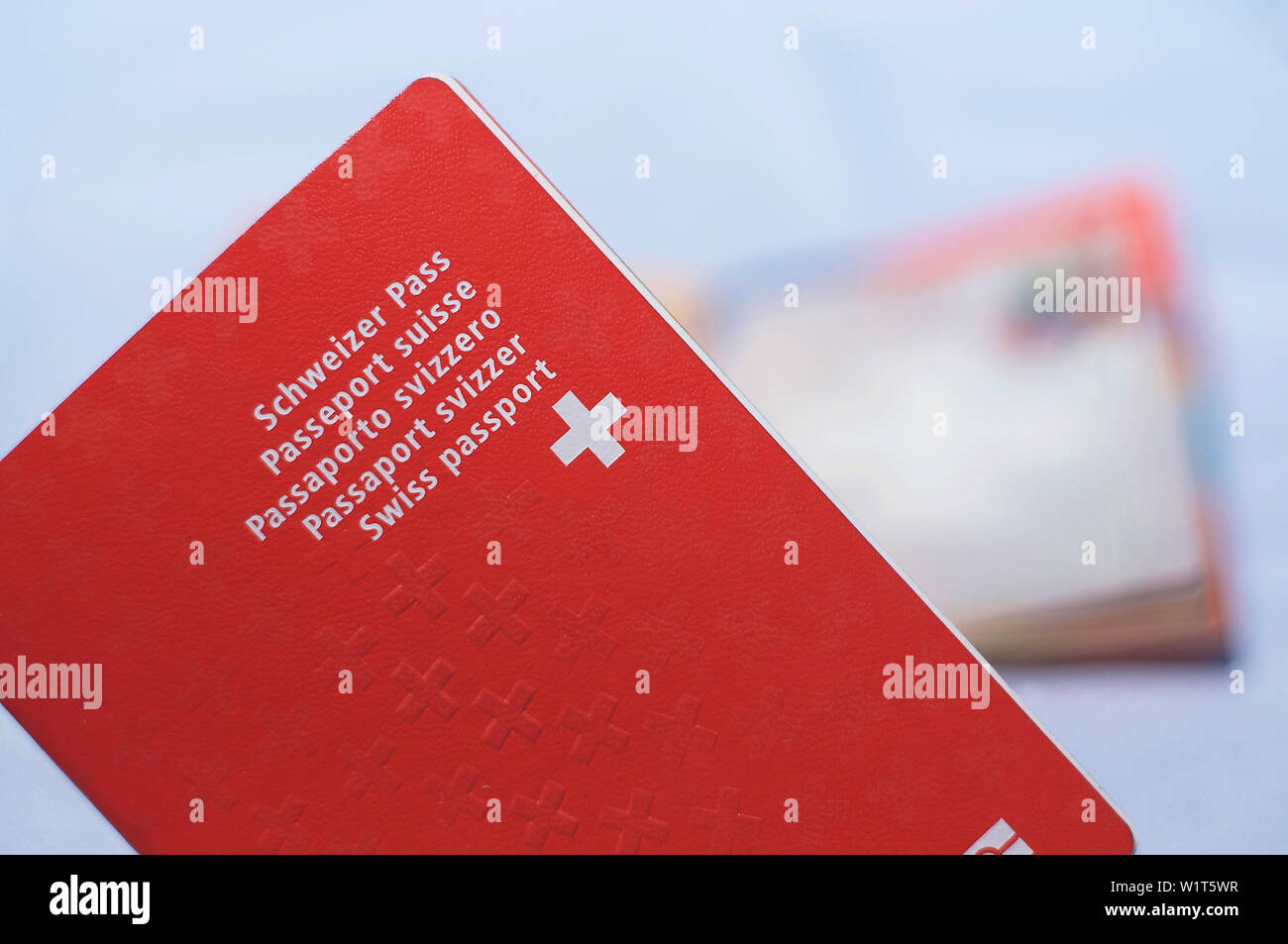 Close up view of one Swiss passports with a blurred open swiss passport