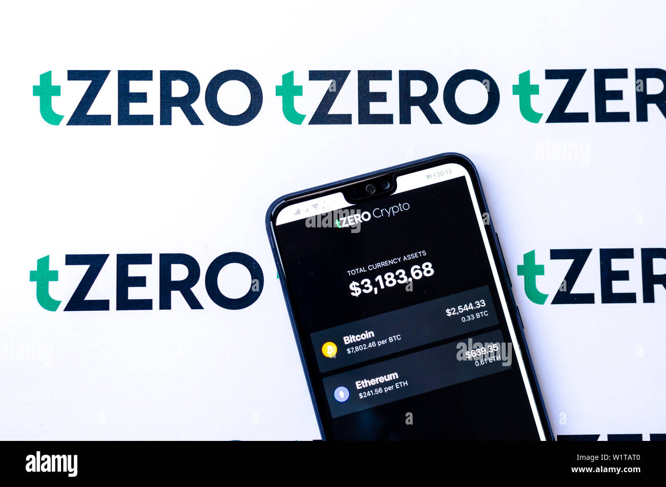 tZero logos on the brochure and the smartphone with the tZERO Crypto App  screenshot Stock Photo - Alamy