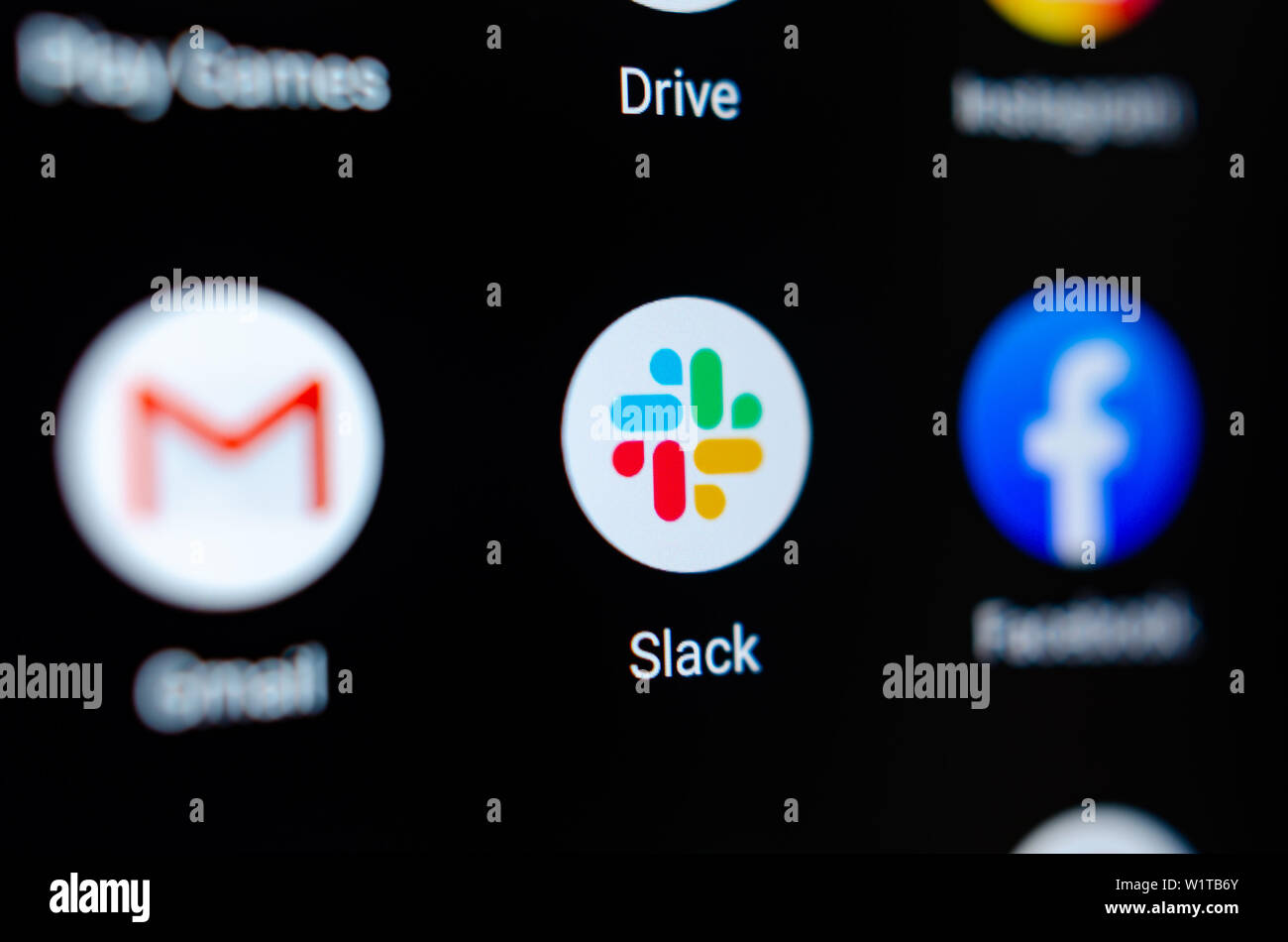 Close up photo Slack app on the smartphone screen and a finger launching it. The top app for communication and collaboration. Stock Photo