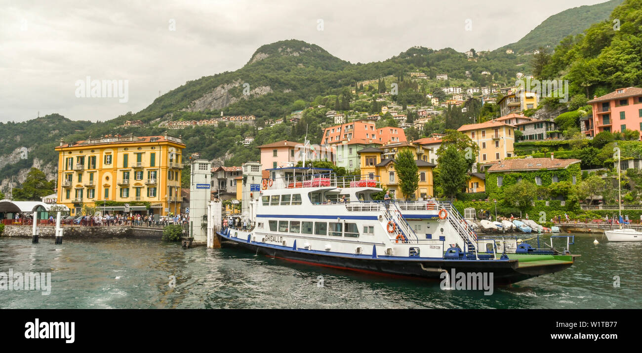VARENNA, LAKE COMO, ITALY - JUNE 2019: Panormaic view of a passenger and car ferry unloading at the jetty in Varenna on Lake Como. Stock Photo