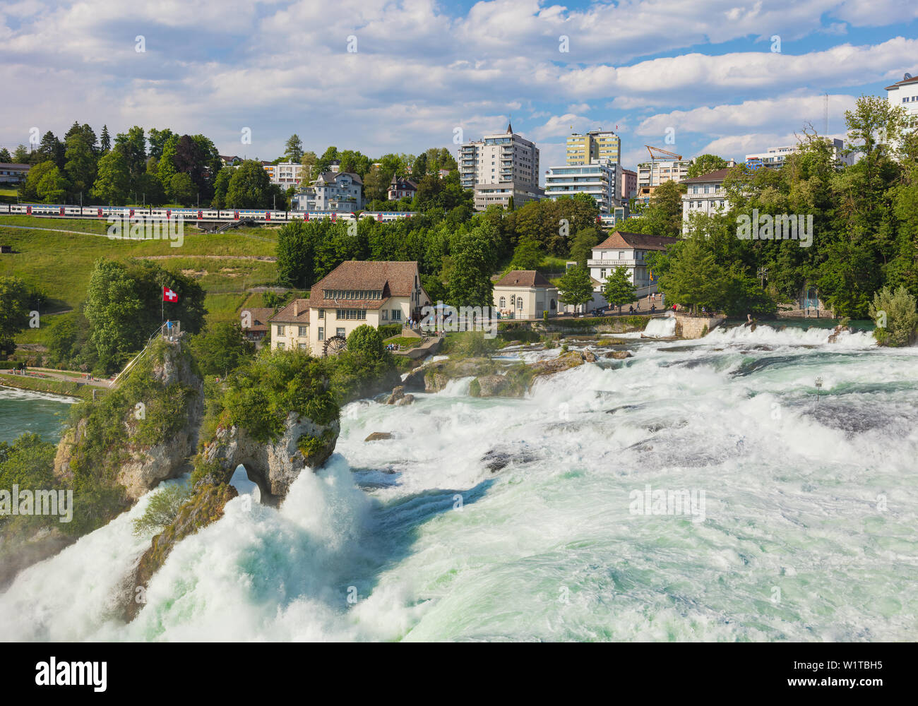 Laufen, Switzerland - June 7, 2019: the Rhine Falls waterfall as seen from the Laufen Castle, buildings of the town of Neuhausen am Rheinfall in the b Stock Photo