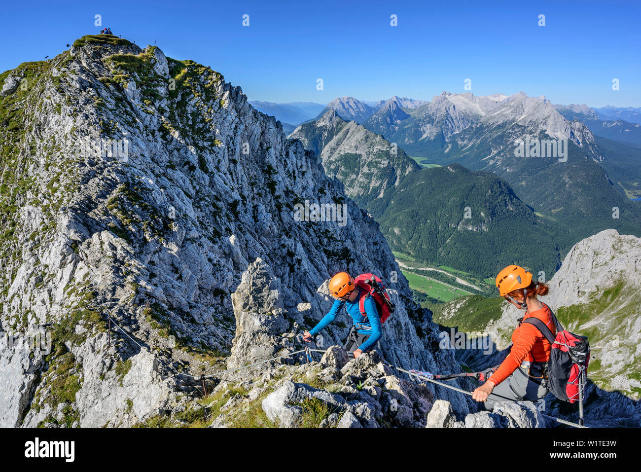 Two women climbing on fixed-rope route Mittenwalder Hoehenweg, Wetterstein range in background, fixed-rope route Mittenwalder Hoehenweg, Karwendel ran Stock Photo