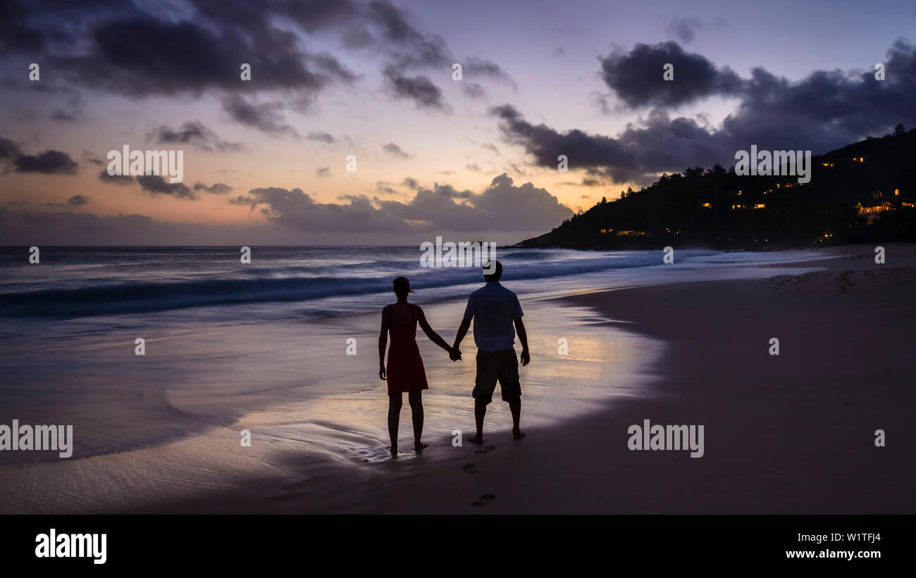enamored couple during sunset at Intendance beach, Mahé, Seychelles Stock Photo