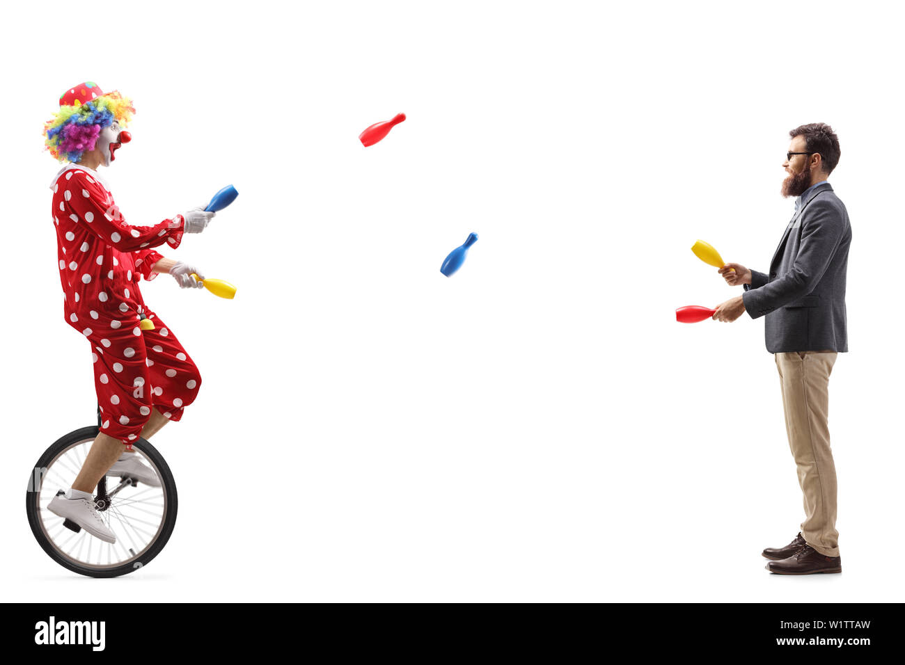 Full length profile shot of a clown on a unicycle juggling with a bearded man isolated on white background Stock Photo