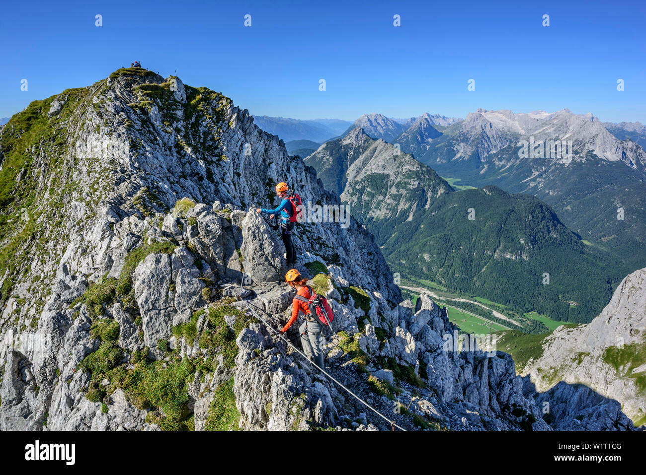 Two women climbing on fixed-rope route Mittenwalder Hoehenweg, Wetterstein range in background, fixed-rope route Mittenwalder Hoehenweg, Karwendel ran Stock Photo