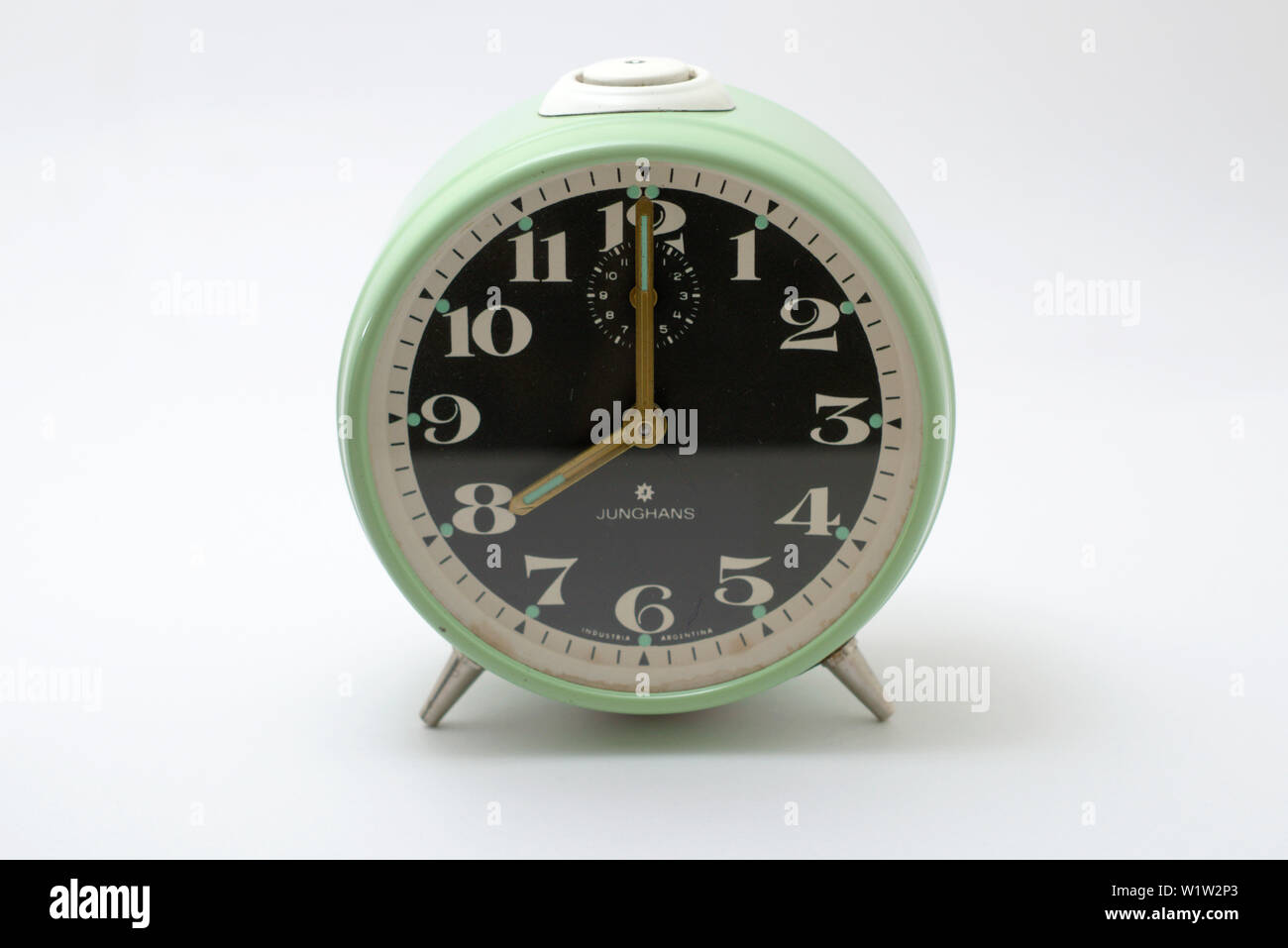 An old Junghans mechanical alarm clock with a white background