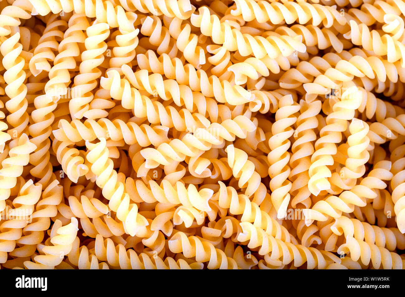 Uncooked fusilli pasta, background Stock Photo