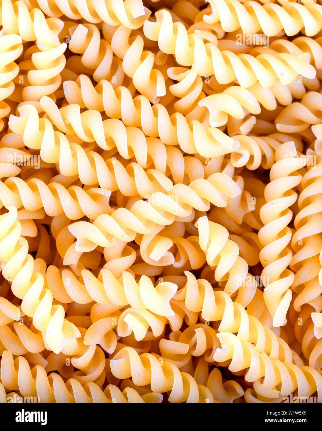 Uncooked fusilli pasta, background Stock Photo