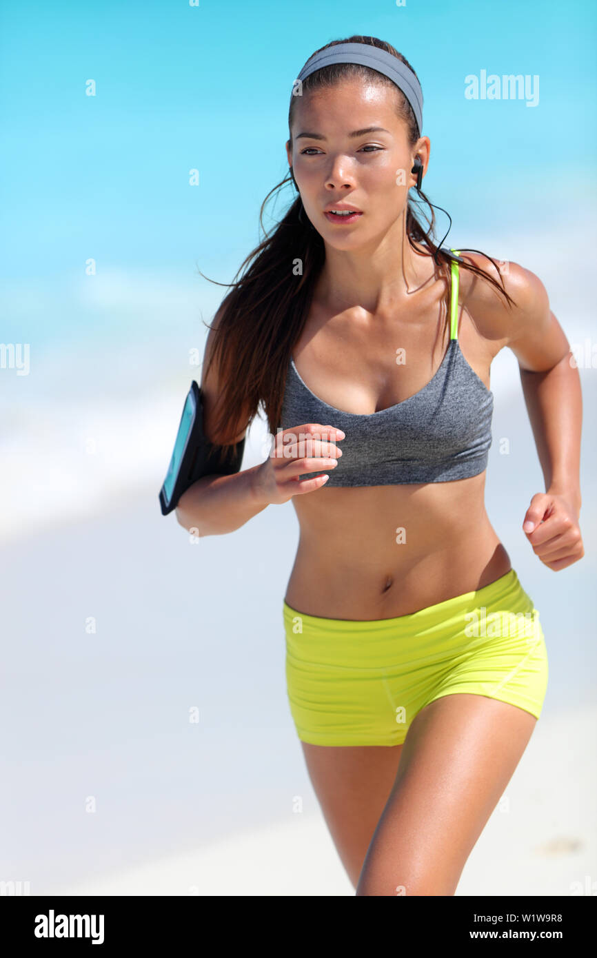 Running runner jogging doing cardio workout on beach in sportswear. Asian  female athlete jogging focused doing endurance training in summer outdoors  Stock Photo - Alamy
