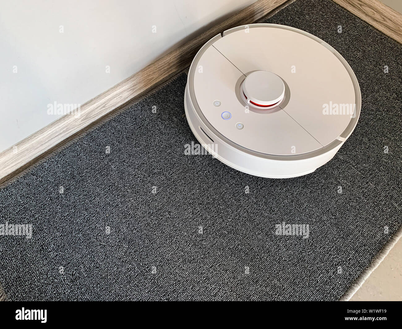 Smart House. Vacuum cleaner robot runs on floor in a living room Stock ...
