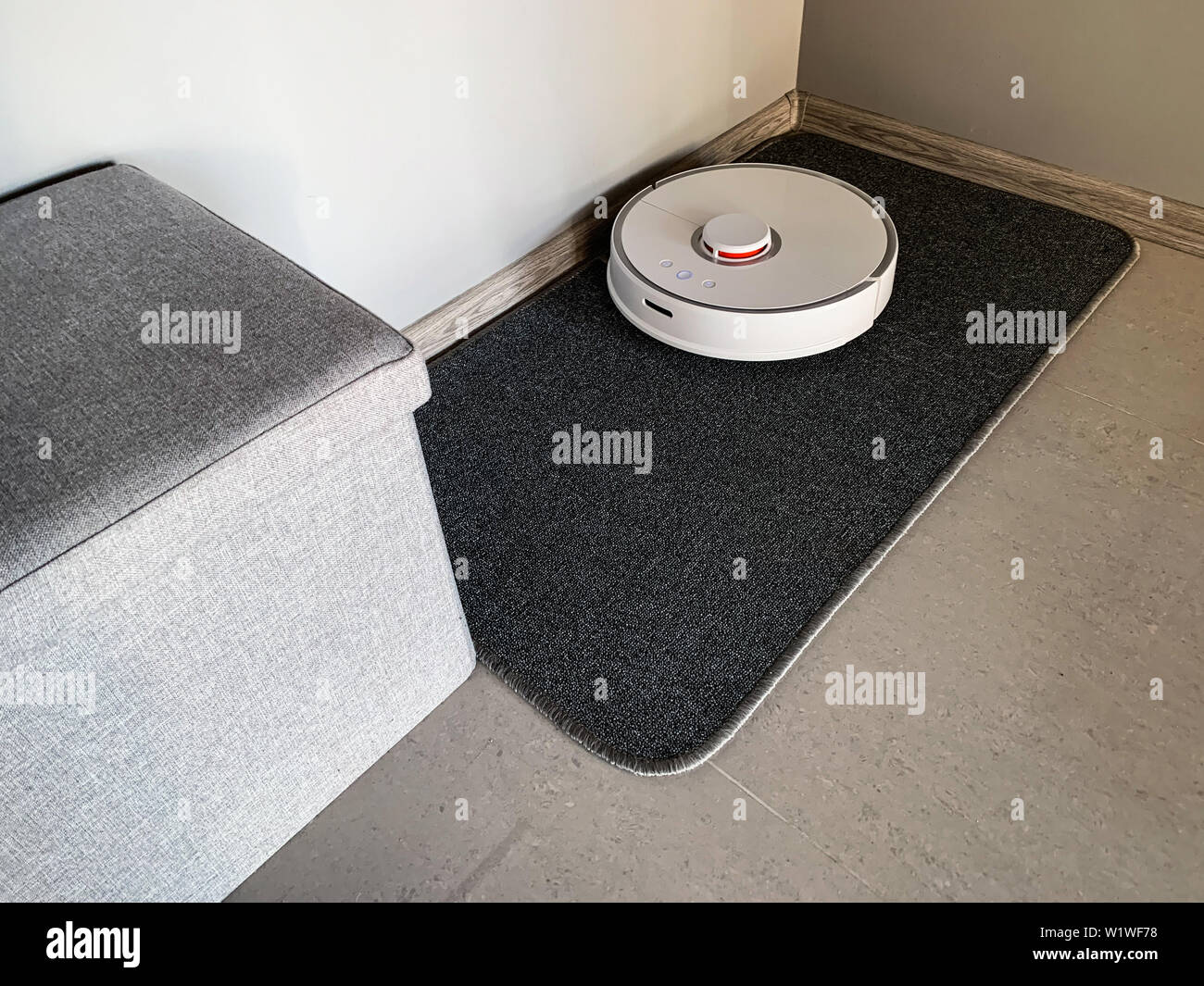 Smart House. Vacuum cleaner robot runs on floor in a living room Stock ...