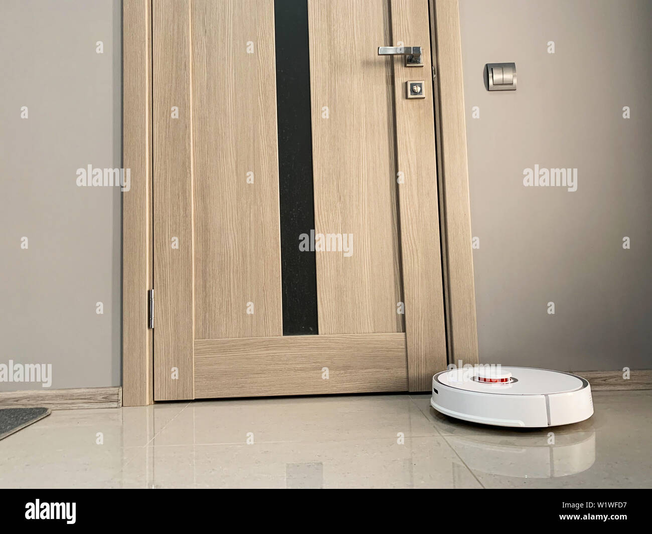 Smart House. Vacuum cleaner robot runs on floor in a living room Stock ...