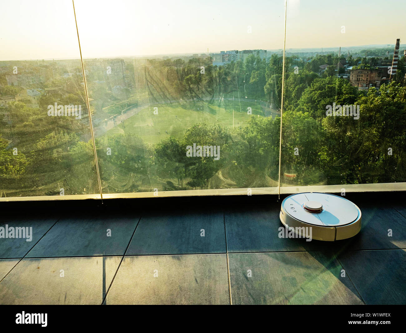 Smart House. Vacuum cleaner robot runs on floor in a living room Stock ...
