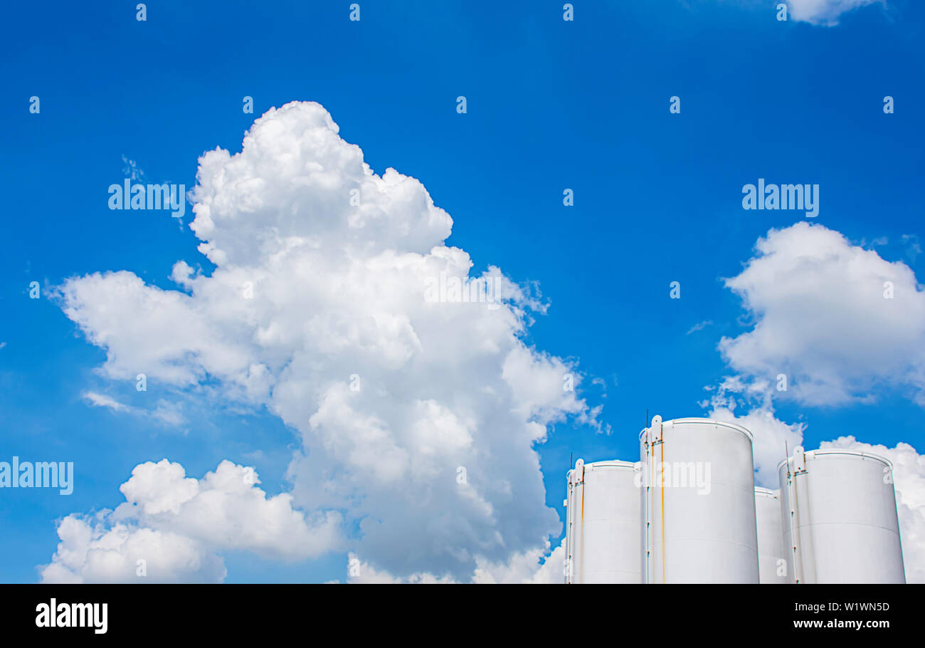 Fuel tanks White and The beauty of the sky with clouds and the sun in summer. Stock Photo