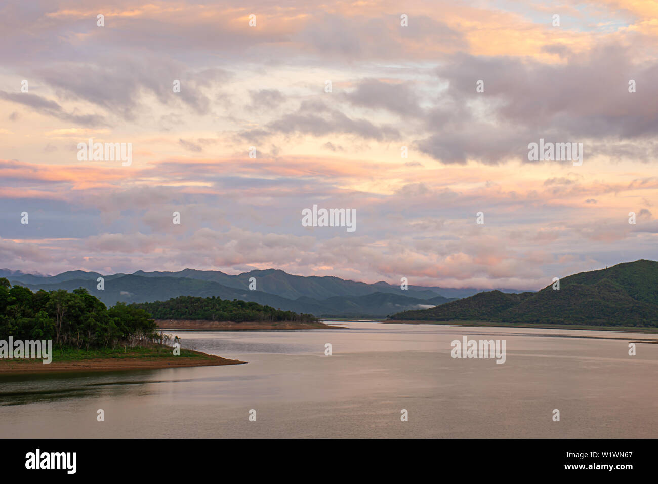 The reflection of the Sun and the clouds on the sky Background mountain and water at Kaeng Krachan dam in phetchaburi , Thailand. Stock Photo