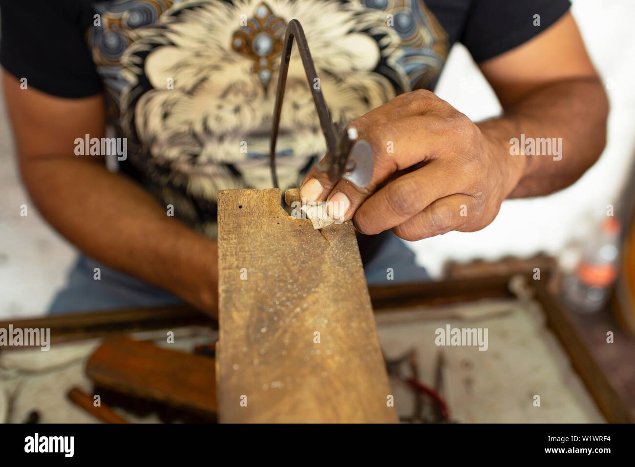 1st step of making jewellery: Mexican silversmith cutting silver plate with a saw at his jewelry workshop in Taxco, Guerrero, Mexico. Jun 2019 Stock Photo