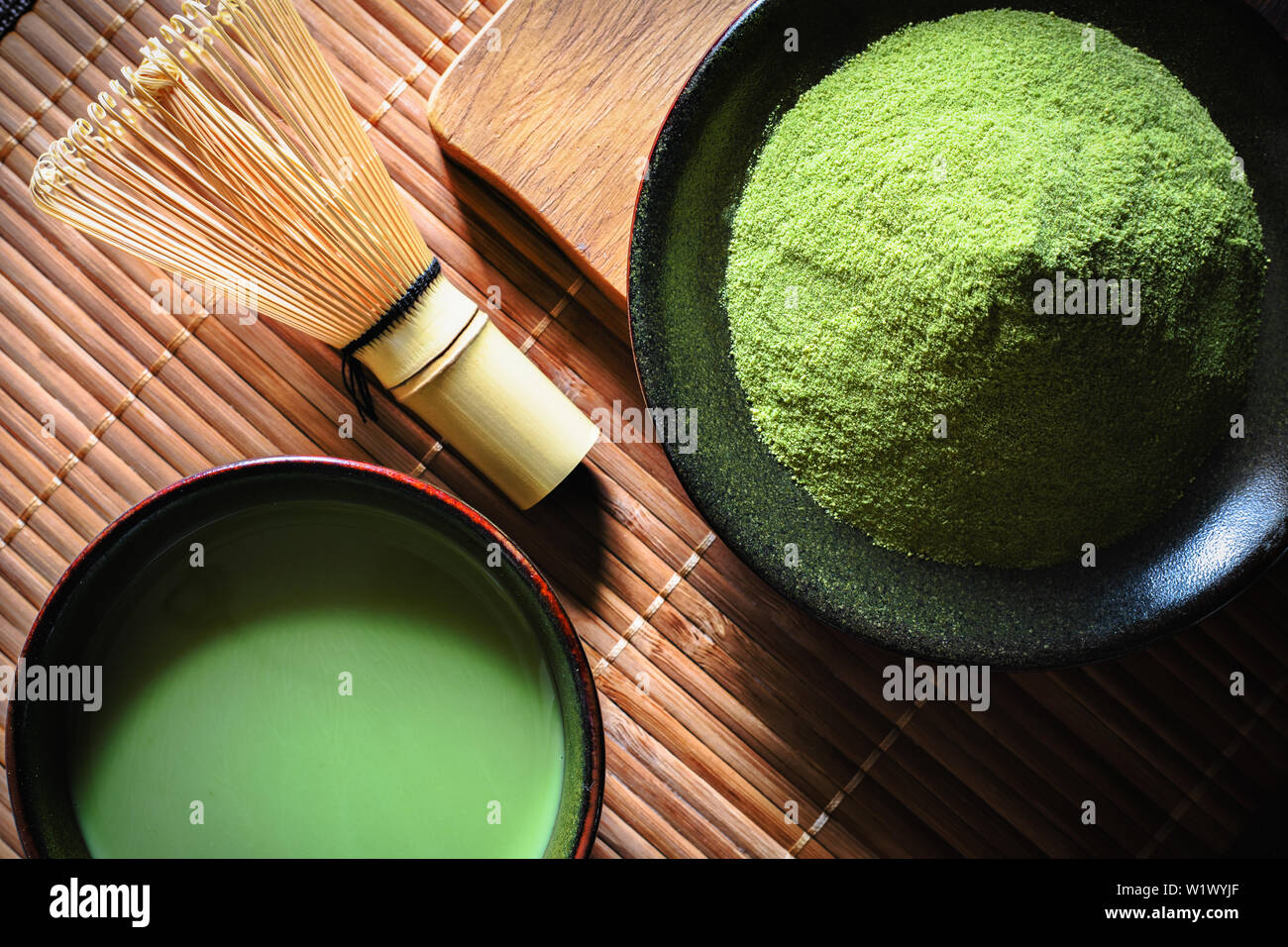 Japanese matcha green tea in a cup and tea powder top view closeup