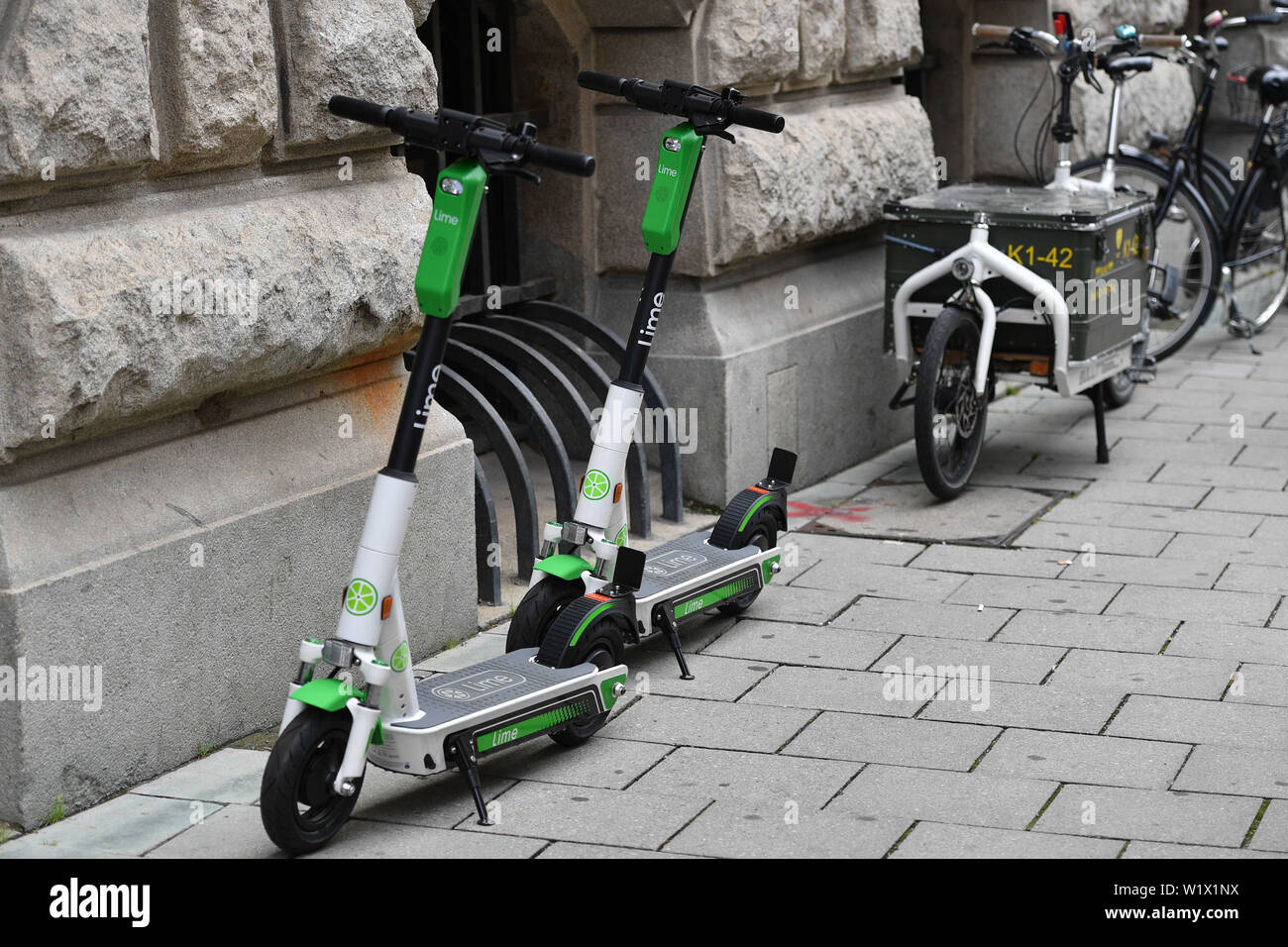 Munich, Deutschland. 02nd July, 2019. LimeBike, Lime Bike US e-scooter  rental company. E-scooters, electric scooters stand on a sidewalk in  downtown Munich. Leihroller, Mietroller, Mietscooter, Miettretroller. |  usage worldwide Credit: dpa/Alamy Live