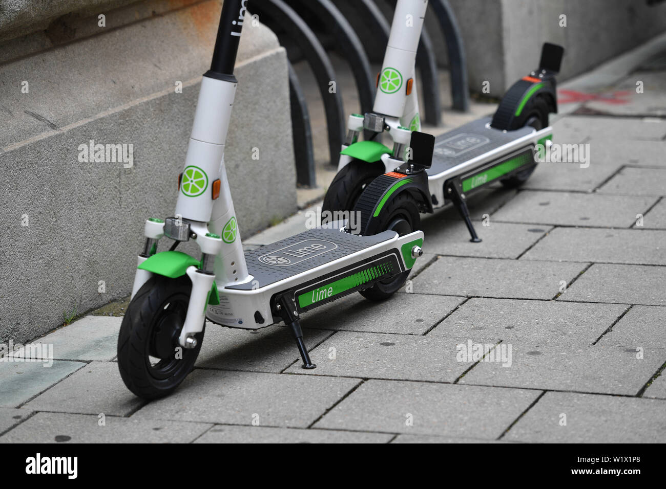 Munich, Deutschland. 02nd July, 2019. LimeBike, Lime Bike US e-scooter  rental company. E-scooters, electric scooters stand on a sidewalk in  downtown Munich. Leihroller, Mietroller, Mietscooter, Miettretroller. |  usage worldwide Credit: dpa/Alamy Live