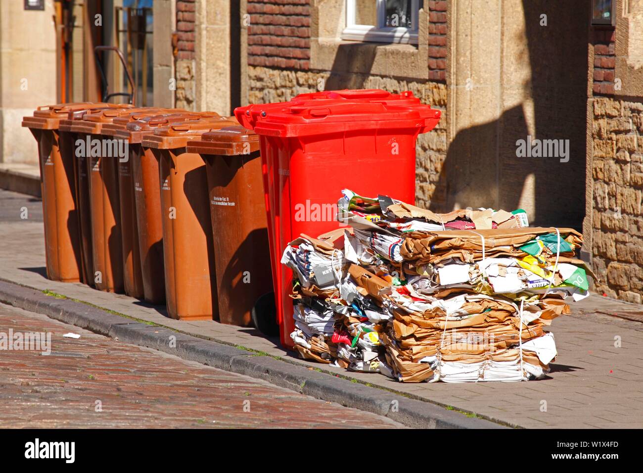 Waste separation, brown bio bins, red bins for waste glass and stacks of waste paper, Germany