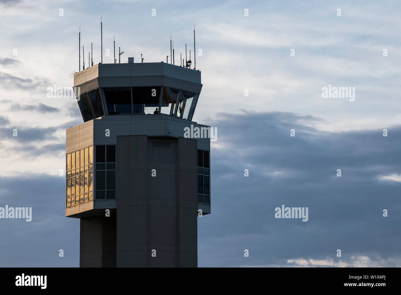 The sun slowly sets, its glow reflecting off the Dover Air Force Base air traffic control tower May 9, 2019, Del. Air traffic controllers are positioned in the tower to ensure every aircraft and vehicle on the airfield is taken care of, as well as every aircraft in flight within a radius of 10 to 15 miles. (U.S. Air Force photo by Senior Airman Christopher Quail) Stock Photo