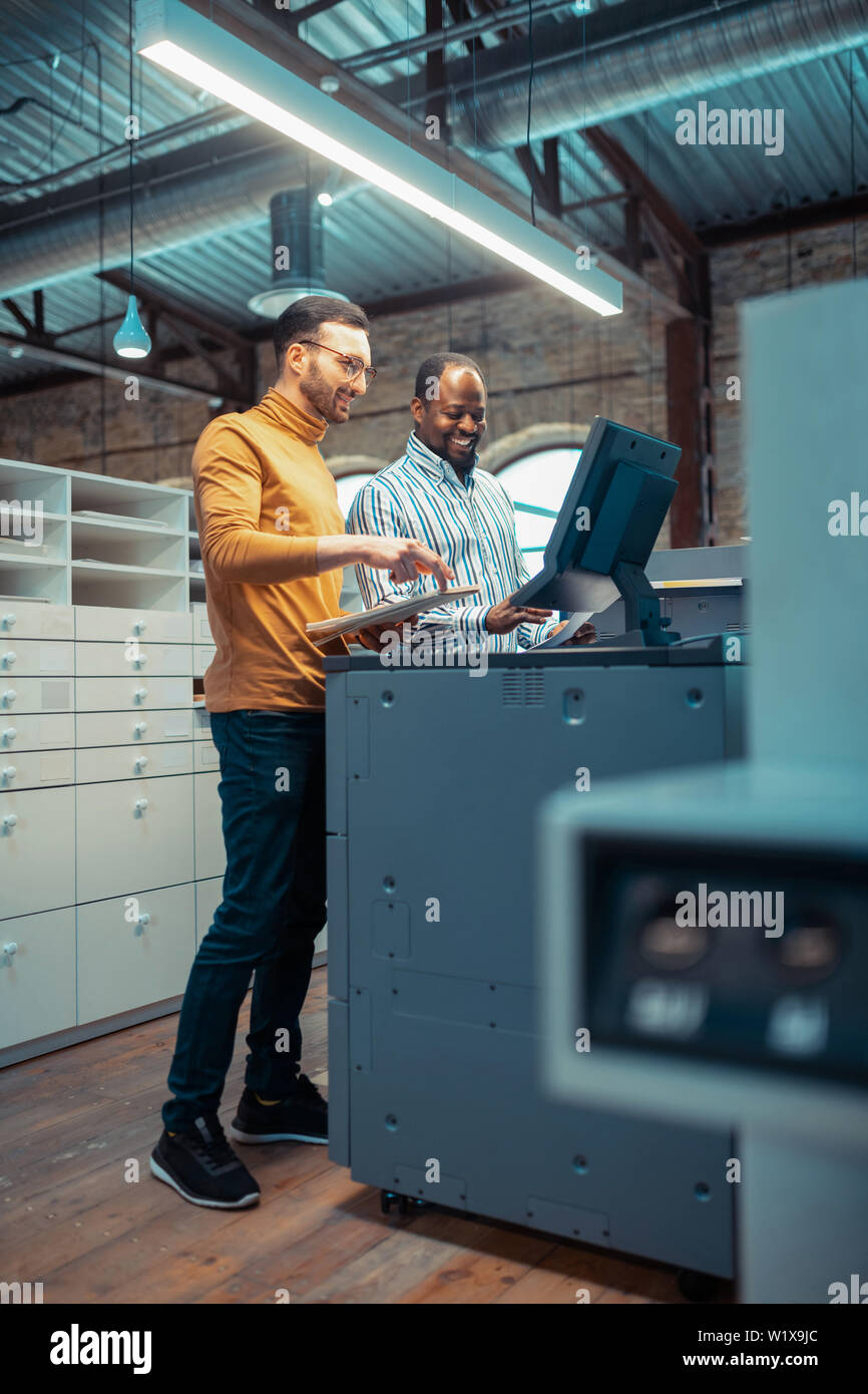 Discussing new project. Two colleagues working in publishing office discussing new project together Stock Photo