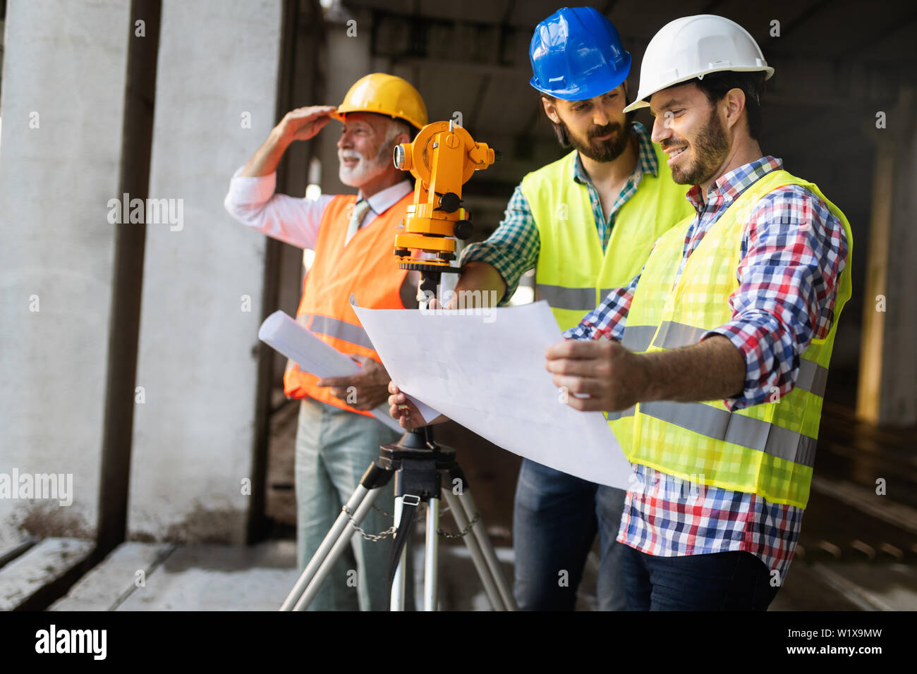 Engineer and building site manager dealing with blueprints and plans ...