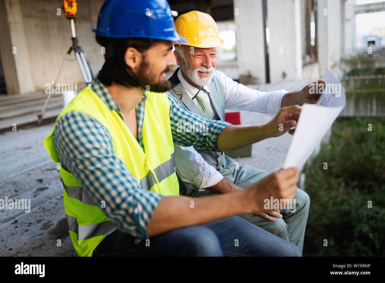 Engineer, foreman and worker discussing in building construction site Stock Photo