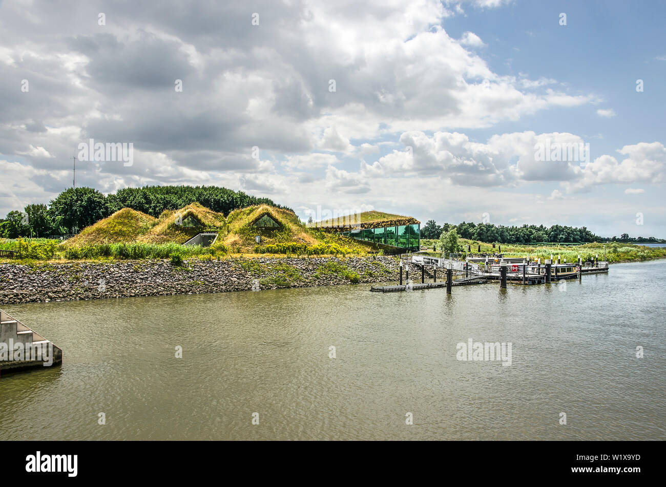 Werkendam, The Netherlands, July 3, 2019: the soil-covered museum and restaurant and the adjacent jetty for tourboats on a summer day in the national Stock Photo