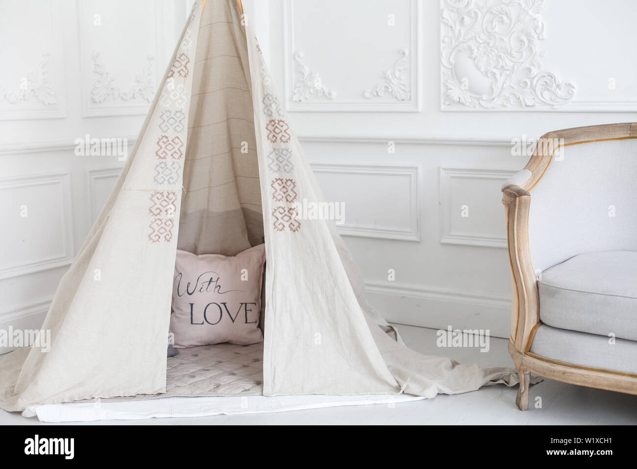 Cozy bright interior of the children's room with a wigwam. Stock Photo