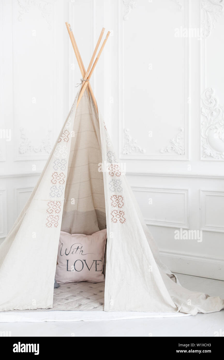 Cozy bright interior of the children's room with a wigwam. Stock Photo