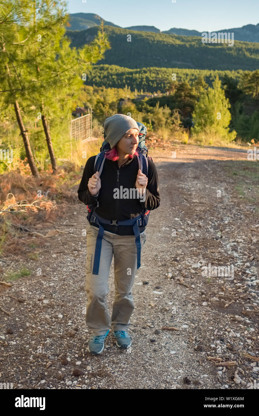 Young woman with backpack walk the Lycian way hiking trail at Mediterranean coast in Turkey. Stock Photo