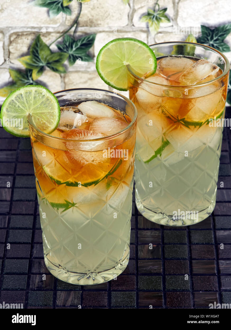 Dark'n Stormy Cocktails made with dark rum and ginger beer, decorated with lime slices Stock Photo