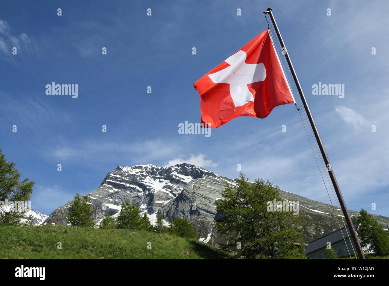 Swiss flag and mountains at San Gotthard mountain pass between Italy and Switzerland Stock Photo
