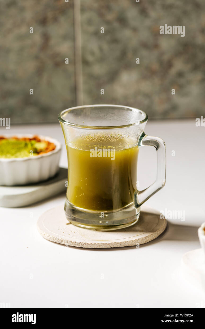 Hot matcha tea in transparent cups on the rustic table Stock Photo