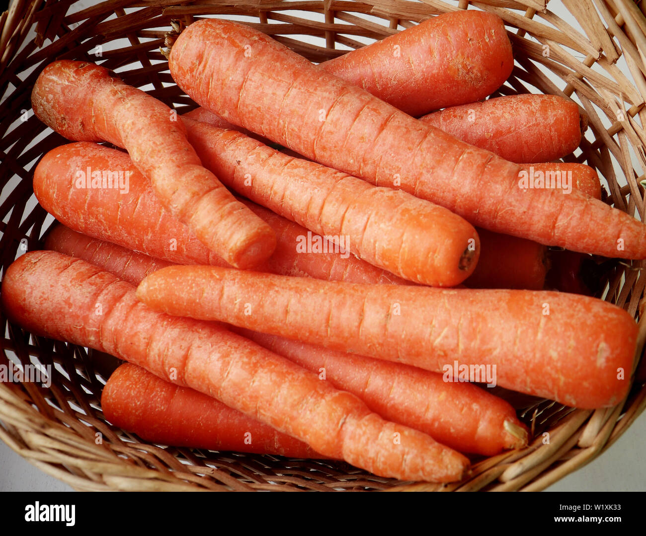 Carrots with bright color in a basket, healthy ingredients in the kitchen Stock Photo