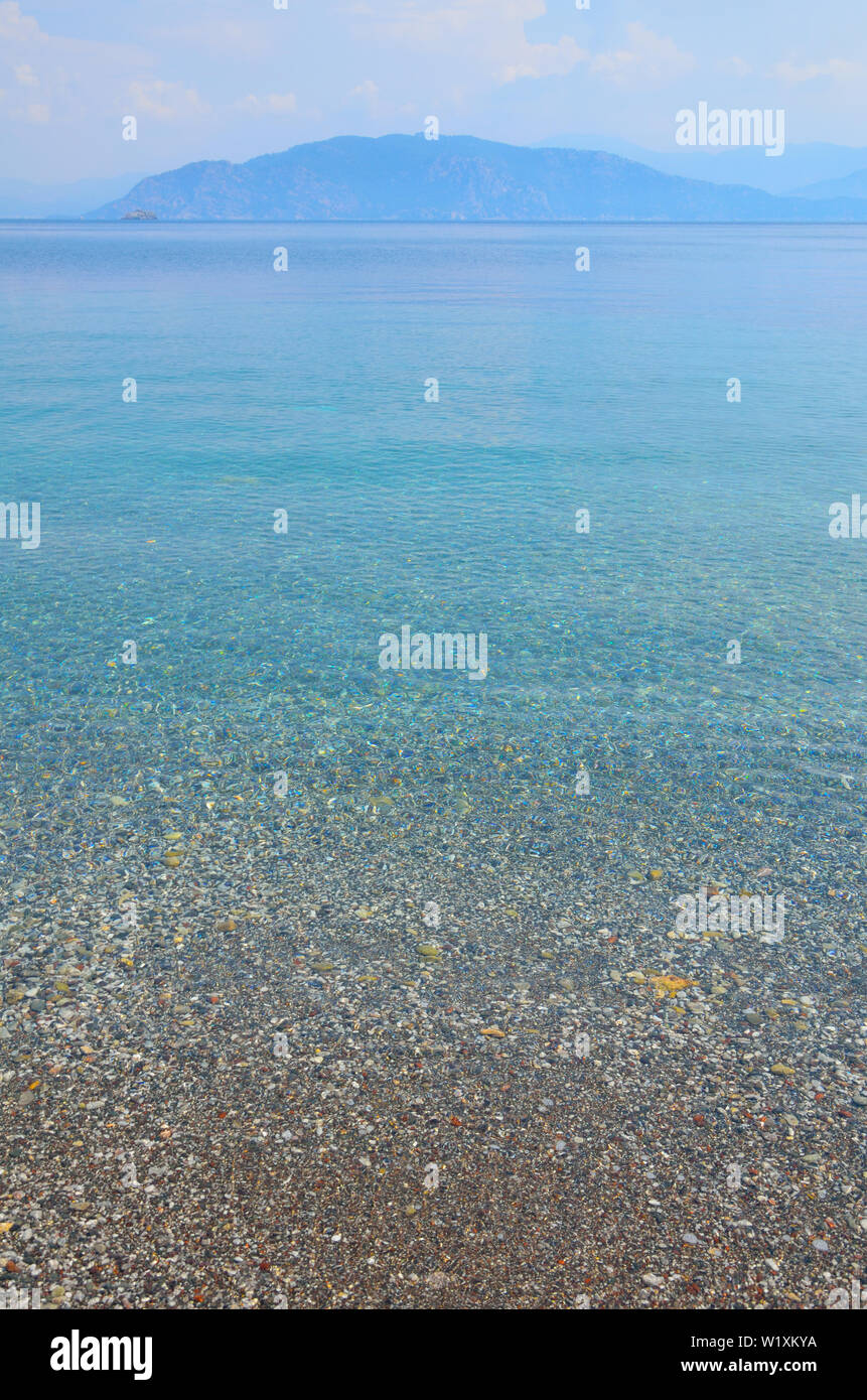 Sea landscape with pebbles and island in Turunc, Turunch Kumlubuk Mugla Stock Photo