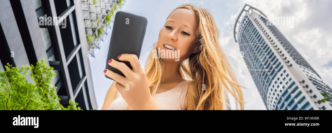 Woman Using Map App On Smartphone On The Background Of Skyscrapers