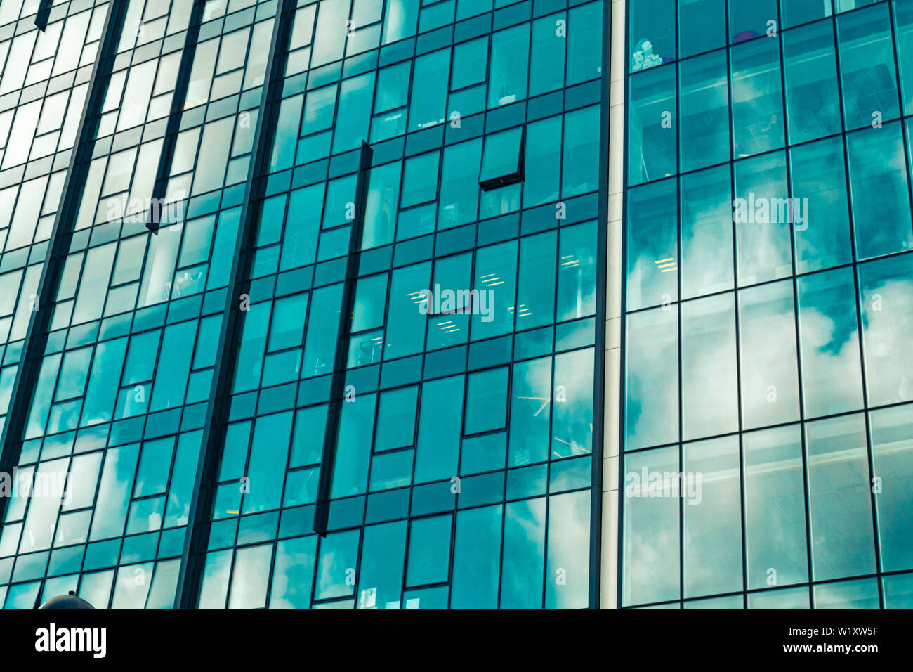 Sky with clouds reflected in windows of modern office building ...