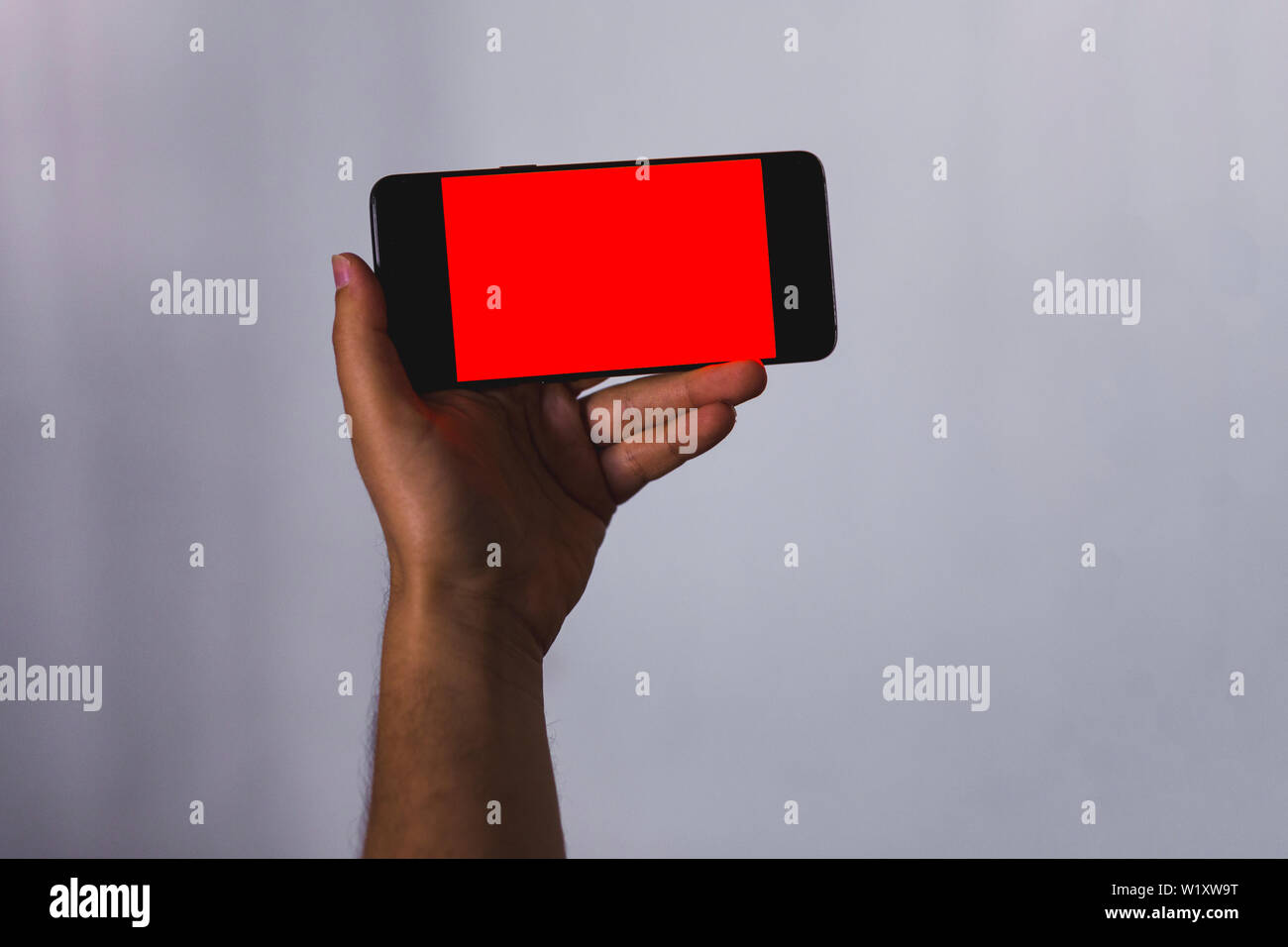 hand holding a smartphone with Empty screen with copy space for text or content Stock Photo