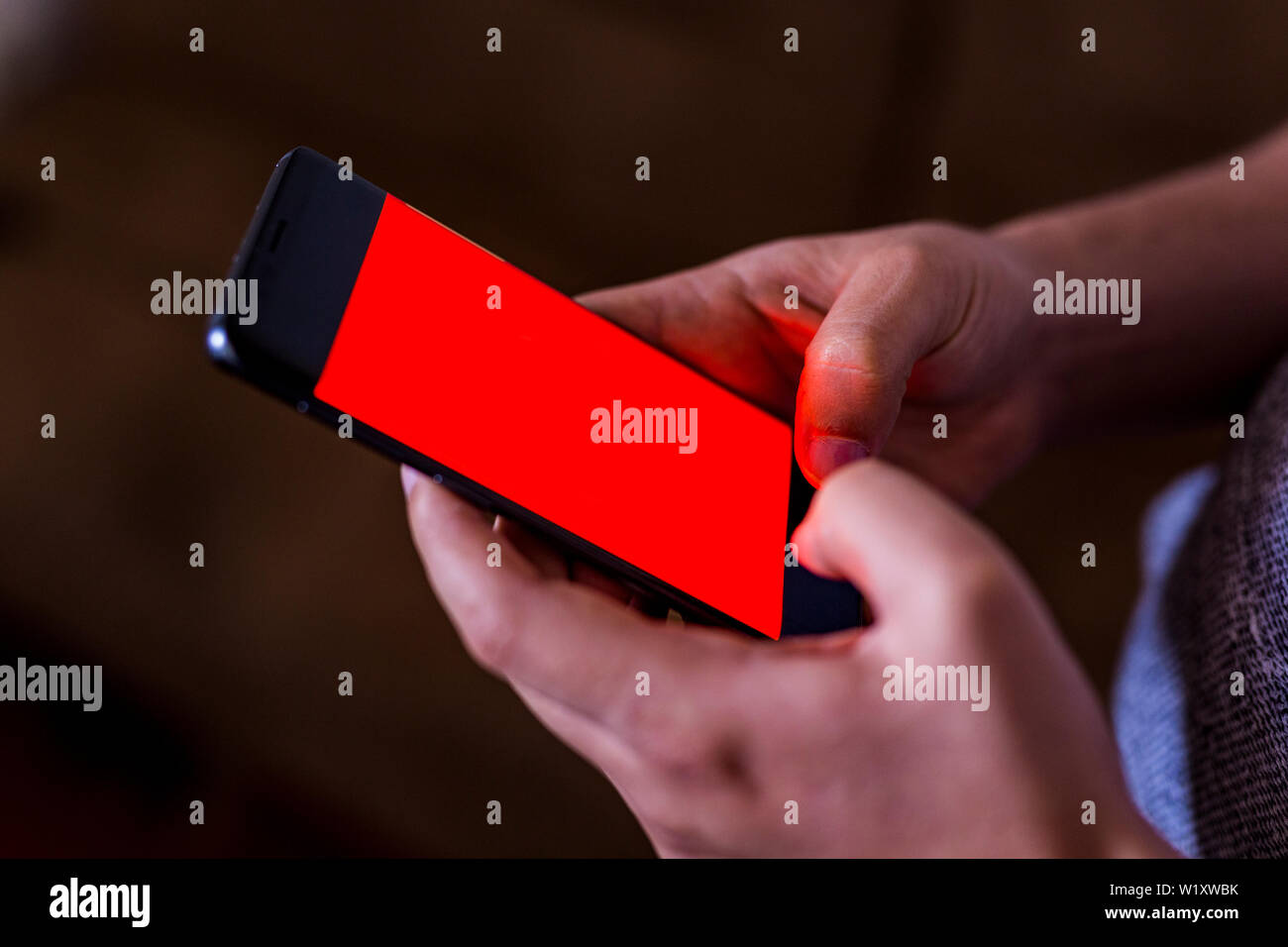 man hand holding mobile phone in coffee shop. Man using smartphone. Empty screen with copy space for text or content Stock Photo