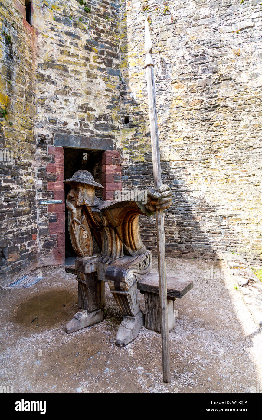 'The Guard' a wooden oak sculpture by John Merrill inside Conwy Castle ruins, Wales, UK Stock Photo