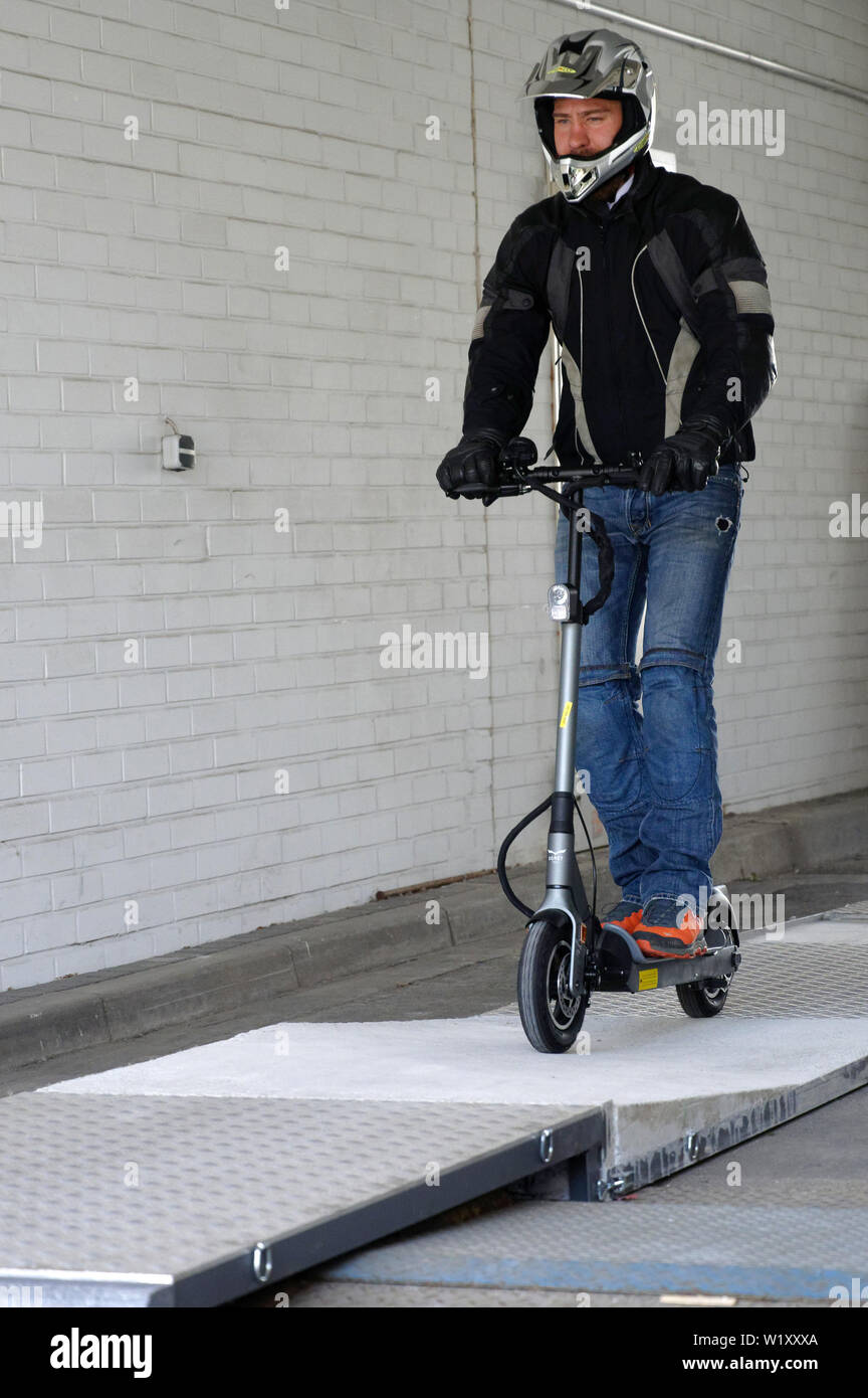 04 July 2019, North Rhine-Westphalia, Cologne: Tester Jens Peuker drives  over a test track at a TÜV Rheinland press conference on the safe handling  of electric scooters with an electric scooter. Photo: